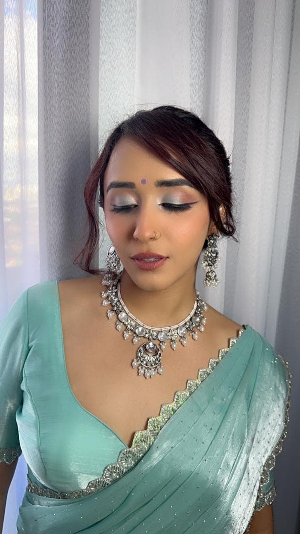 Party glam look in a sea-green saree with statement silver jewellery