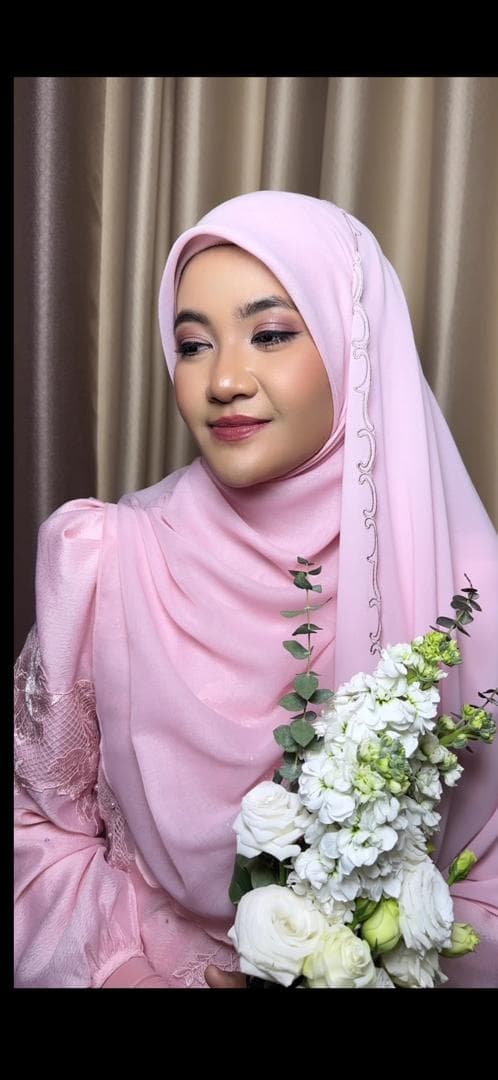Bridal look in a blush pink hijab with a floral bouquet