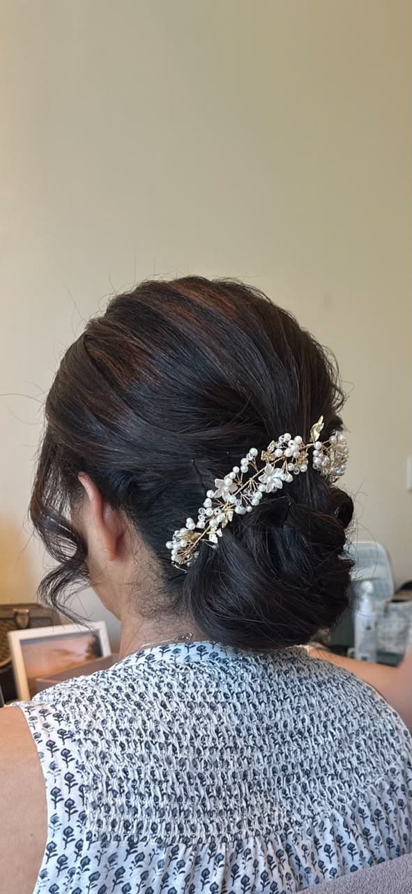 Bridal hair styled in an updo with a pearl hair vine